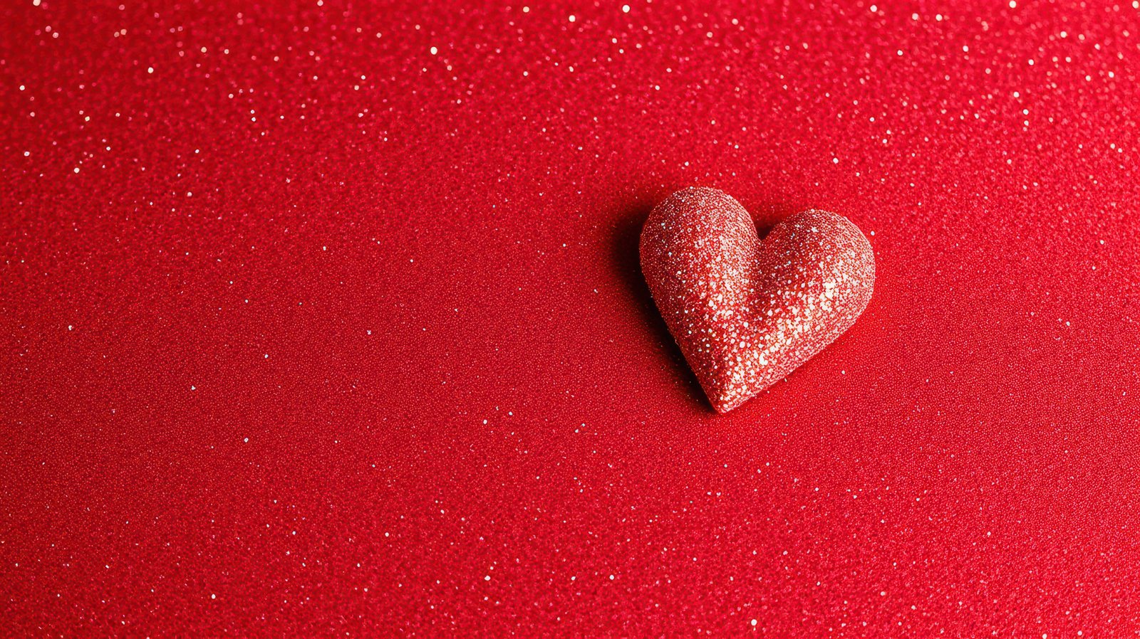 Sparkling red heart decoration on vibrant backdrop shining with glitter and color